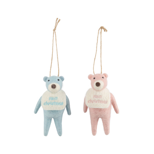 teddy bear ornaments, one blue and one pink, with 'first christmas' sweaters on a white background.