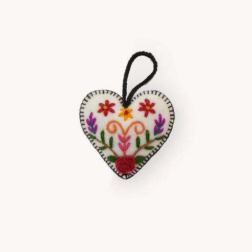 Heart-shaped embroidered ornament with floral patterns on a white background